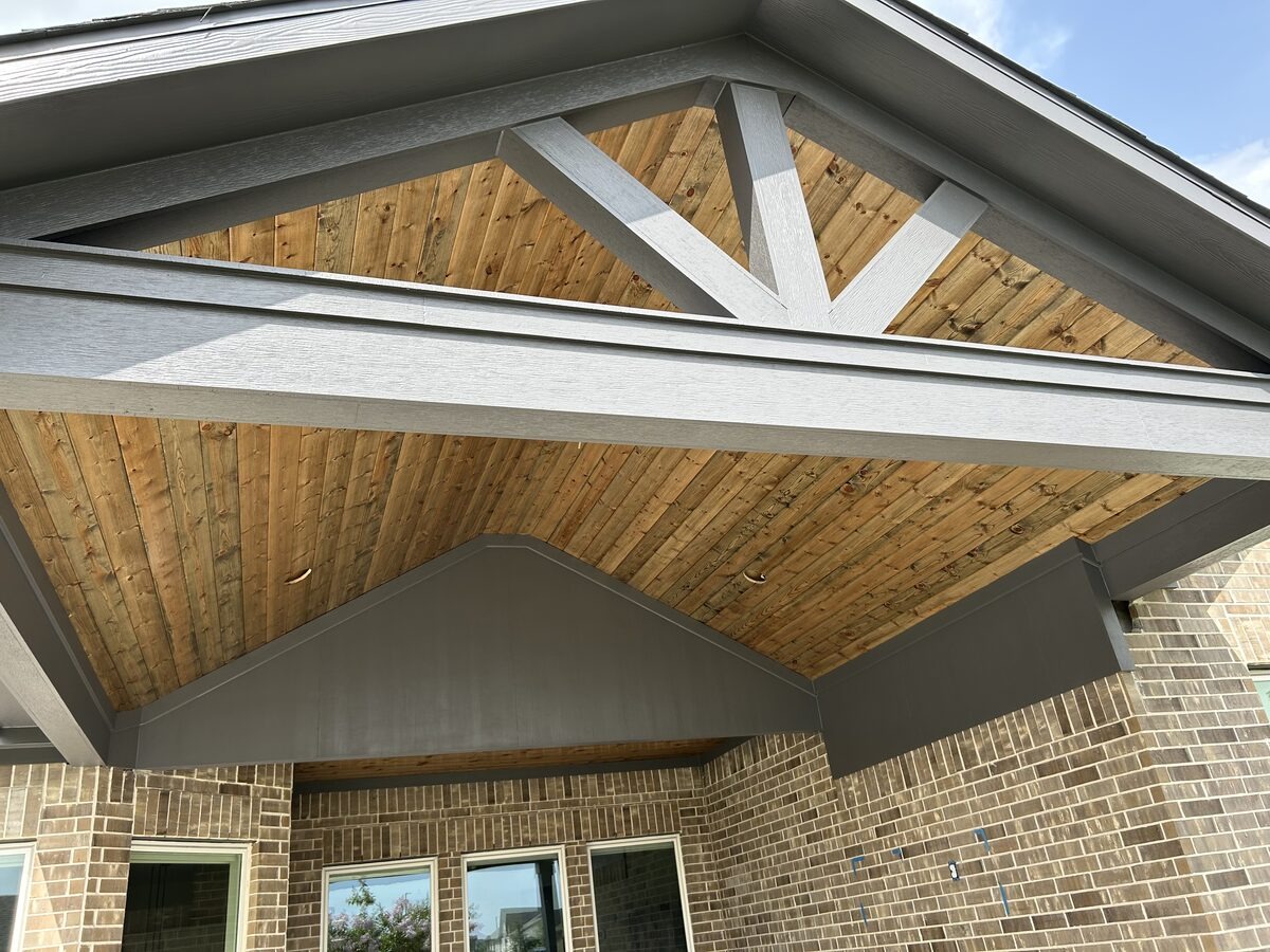 Attached patio cover with stained cedar ceiling and decorative truss