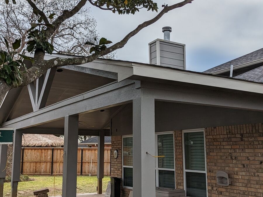 Attached gable roof patio cover on a brick home in Magnolia, TX