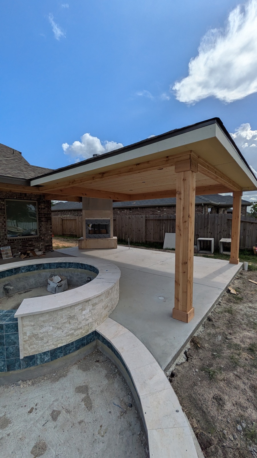 Freestanding poolside patio cover with outdoor fireplace